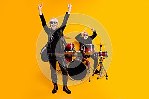 Portrait of attractive elderly cheerful grey-haired couple performing hit genre having fun fame showing horn sign