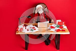 Portrait of attractive elderly retired cheery Santa using laptop sending wishes advent email isolated over bright red