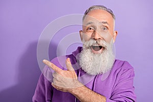 Portrait of attractive elderly retired pensioner trendy grey-haired man showing cool offer isolated over purple violet