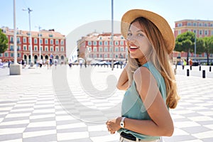 Portrait of attractive fashion woman turns around and smiling at camera in Nice City, France