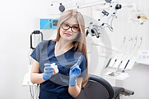 Portrait of attractive female dentist with dental floss in the dental clinic