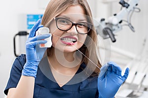 Portrait of attractive female dentist with dental floss in the dental clinic