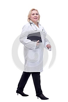 Portrait of attractive female doctor walking with clipboard