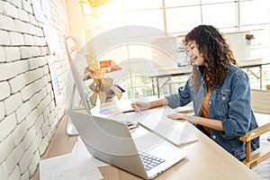 Portrait of attractive female graphic designer sitting at desks and drawing artworks on paper. Creative people work in office with