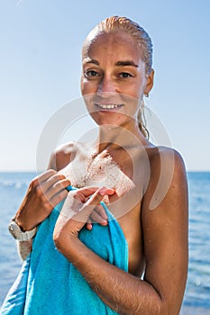 Portrait of attractive female person with wet slicked hair against sea photo