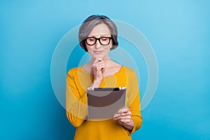 Portrait of attractive focused woman holding in hands using gadget reading blog post media isolated over vivid blue