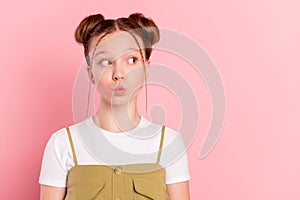 Portrait of attractive funky minded pre-teen girl sending air kiss copy space isolated over pink pastel color background