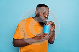 Portrait of attractive funny amazed guy drinking soda free spare time isolated over bright blue color background