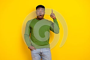 Portrait of attractive funny amazed guy pointing up copy space isolated over vibrant yellow color background