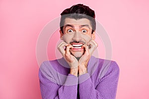 Portrait of attractive funny guy biting nails worrying expecting news isolated over pink pastel color background