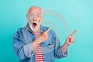 Portrait of attractive funny stunned grey-haired man showing copy space novelty ad isolated over bright teal turquoise