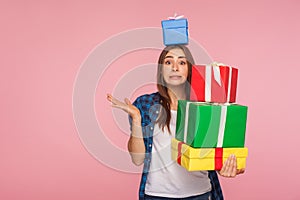 Portrait of attractive girl looking at camera with guilty apologetic expression and holding many gifts