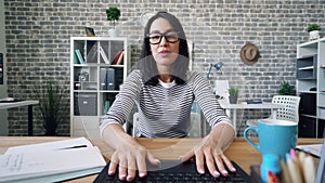 Portrait of attractive girl making video call with laptop in office smiling