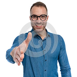 Portrait of attractive guy with glasses smiling and shaking hand