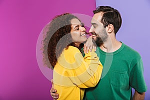 Portrait of attractive happy couple man and woman in colorful clothing smiling and hugging together