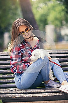 Portrait of attractive happy smiling young woman holding cute little dog