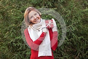 Portrait of attractive happy young woman with Christmas gift box in her hands