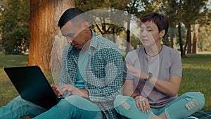 Portrait of attractive hearing impaired couple with devices working in park