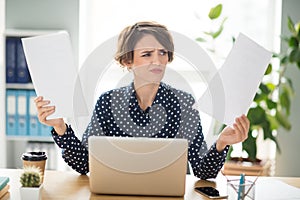 Portrait of attractive irritated girl finance specialist reviewing reading assignment finance result at workplace