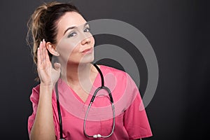 Portrait of attractive lady doctor showing can`t hear gesture