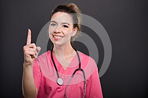 Portrait of attractive lady doctor showing number one gesture