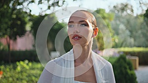 Portrait attractive lady walking sunny nature. Elegant woman strolling park.