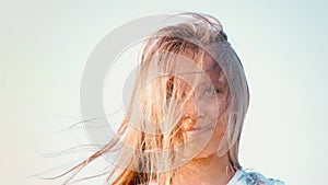 Portrait of attractive little girl with a big green eyes with developing hair against a clear sky, girly with long hair