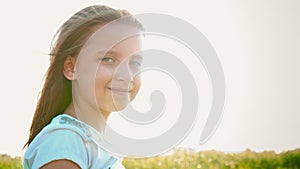 Portrait of attractive little girl with a big green eyes on nature background with developing hair