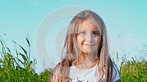 Portrait of attractive little girl with a big green eyes on nature background with developing hair