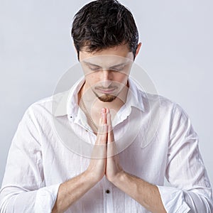 Portrait of attractive man with dark hair in white shirt in yoga