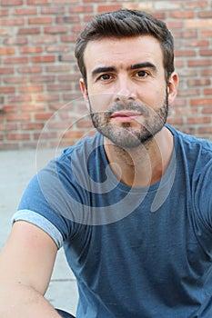 Portrait of attractive man on red brick wall background / Closeup of young interesting natural male