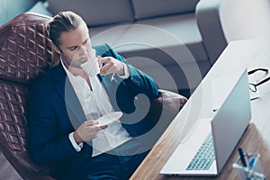 Portrait of attractive manager sitting at his desk in work place