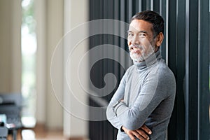Portrait attractive mature asian man retired with stylish short beard smiling at coffee shop outdoor.