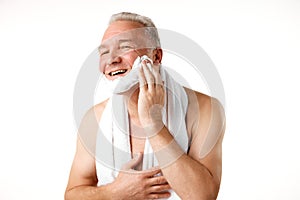 Portrait of attractive middle aged, 45s man applying shaving foam on face preparing to shave with razer against white