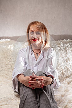 Portrait of an attractive middle-aged woman. Homemade portrait on the couch, middle-aged blonde