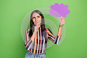 Portrait of attractive minded girl holding in hand violet cloud copy space clue guess strategy isolated over green