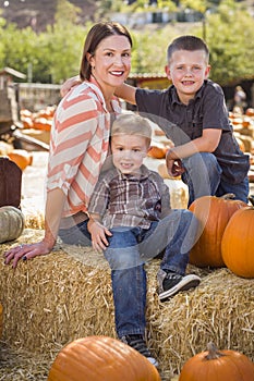 Portrait of Attractive Mother and Her Sons at Pumpkin Patch