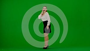 Portrait of attractive office girl on chroma key green screen. Woman in skirt and blouse posing with surprised face