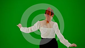 Portrait of attractive office girl on chroma key green screen. Woman in skirt and blouse walking cutely. Back view.