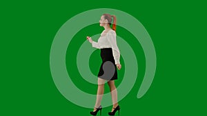 Portrait of attractive office girl on chroma key green screen. Woman in skirt and blouse walking cutely. Side view.
