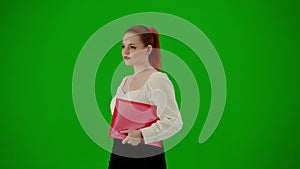 Portrait of attractive office girl on chroma key green screen. Woman in skirt and blouse walking with paper folder and