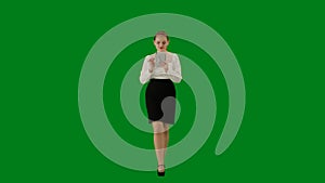 Portrait of attractive office girl on chroma key green screen. Woman in skirt walking and holding tablet, positive