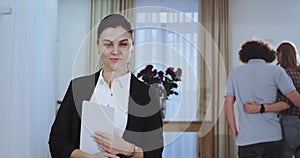 Portrait attractive real estate agent woman end the meeting with her client while young couple happy analyzing the house