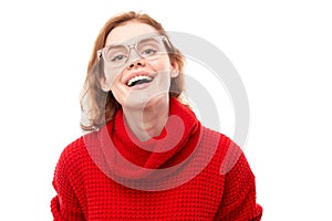 Portrait of attractive red-haired girl in red Christmas sweater smiling joyfully