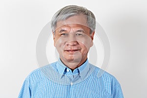 Portrait of attractive senior asian man smiling and looking at camera in studio