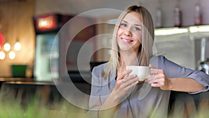 Portrait of attractive smiling businesswoman enjoying break drinking coffee holding big white cup
