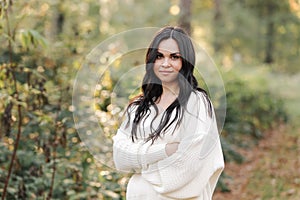 Portrait of attractive smiling caucasian brunette woman is looking in camera. The face of a happy and relaxing beautiful