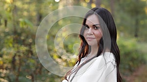 Portrait of attractive smiling caucasian brunette woman is looking in camera. The face of a happy and relaxing beautiful