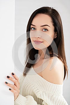 Portrait of attractive smiling young woman posing at home and looking at camera