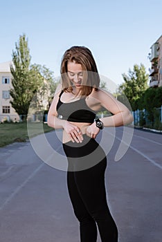 Portrait of attractive sport woman in sportswear posing outdoors at the stadium